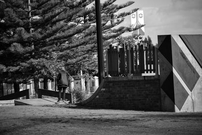 Man hanging in park against building