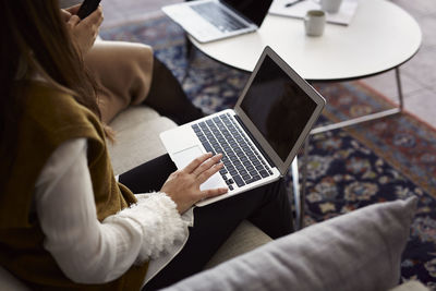 Mid section of woman using laptop