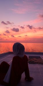 Man looking at sea against sky during sunset