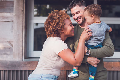 Family of three playing in downtown, mom is trying to make son smile