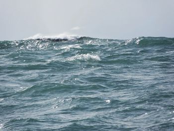 Waves in sea against sky