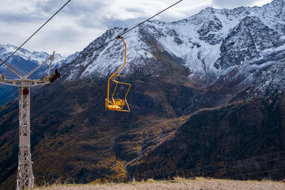 Mountain landscape with a moving chair of a single-seat cable car for hikers and climbers.