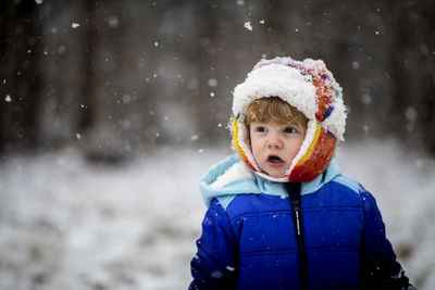 Portrait of smiling boy standing in snow