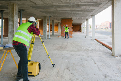 Surveyor engineer working at construction site with measuring equipment (total station)