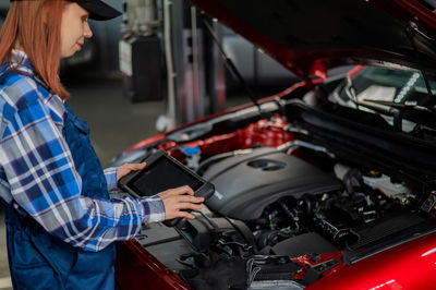 Rear view of man repairing car