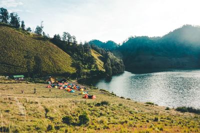 People on mountain by road against sky