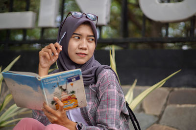 Portrait of young woman using mobile phone