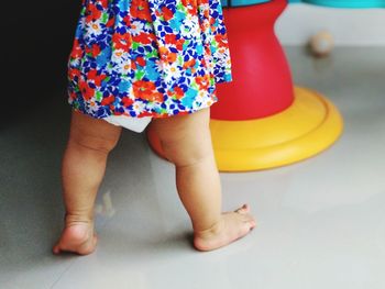 Low section of baby girl standing on tiled floor