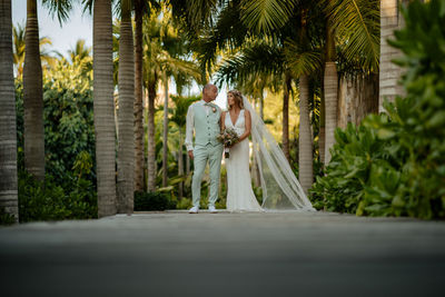 Couple walking on palm trees