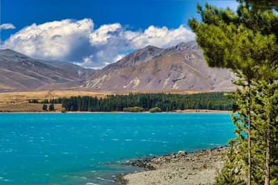 Scenic view of lake by mountains against sky