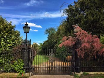 Scenic view of gate against cloudy sky