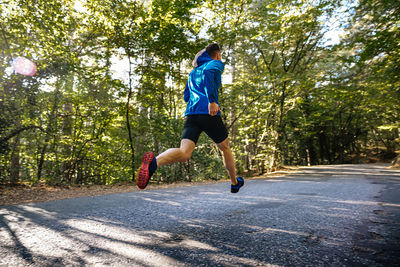 Rear view of man running on road