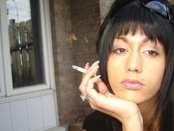 Portrait of young woman holding cigarette