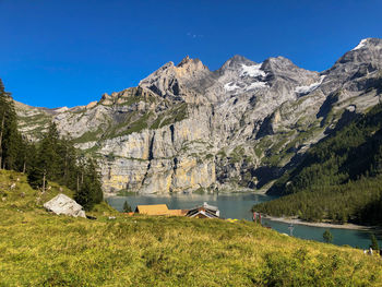 Scenic view of lake and mountains against blue sky