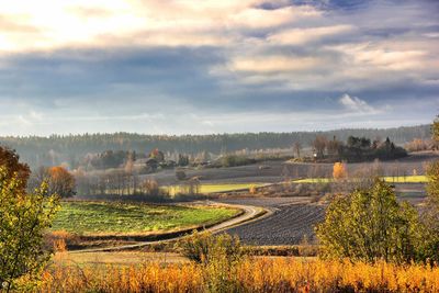 Scenic view of field against cloudy sky