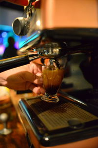 Close-up of coffee cup being field on coffee machine