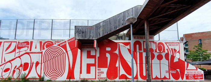 Low angle view of text on building against sky