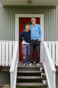 Couple standing in front of house