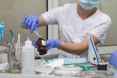 Midsection of nurse holding equipment