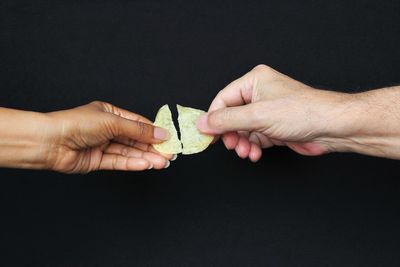 Cropped image of people hand against black background
