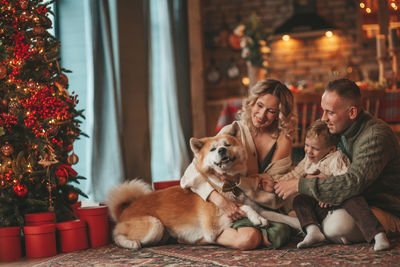 Candid authentic happy family during wintertime together enjoying holidays with dog at xmas