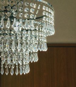 Low angle view of illuminated light bulb hanging at home