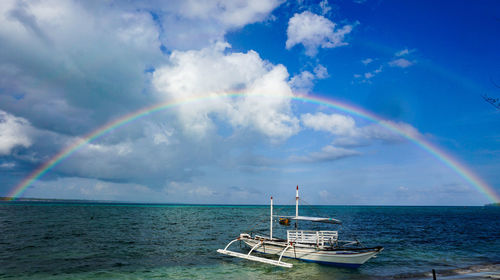 Scenic view of rainbow over sea against sky