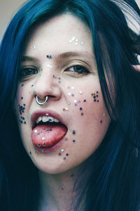 Close-up portrait of young woman with star shape glitters on face