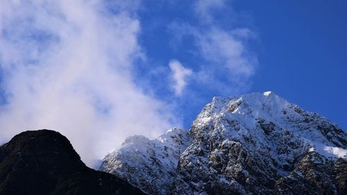 Low angle view of snowcapped mountain against sky