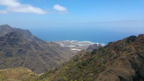 Scenic view of sea and mountains against sky