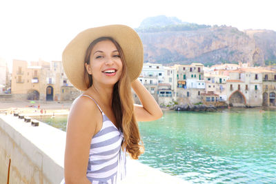 Portrait of smiling young woman standing in city