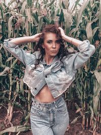 Portrait of beautiful young woman standing in grass