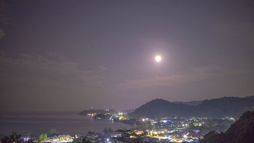 Illuminated cityscape against sky at night