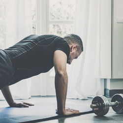 Sporty man working out and trains at home. fit male doing exercise. wellness, health, sport concept