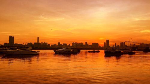 Boats in calm sea at sunset
