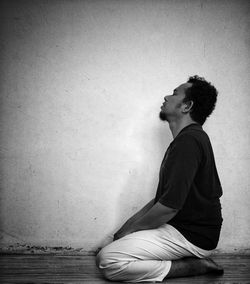 Side view of young man sitting outdoors