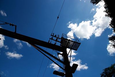 Low angle view of silhouette cranes against sky