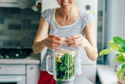 Midsection of woman making juice at home