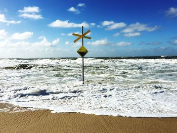 Close-up of lifeguard hut on beach against sky