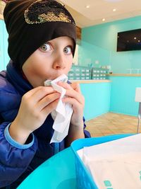 Portrait of boy holding ice cream on table