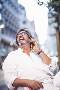 Midsection of man using mobile phone outdoors