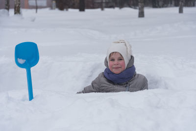 Portrait of cute girl on snow covered landscape