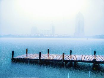 Scenic view of jetty leading to lake on rainy day