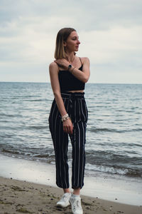 Young woman standing on blurred beachside background. attractive female enjoying walking the sea