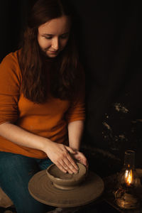 Woman makes plate of clay in pottery workshop, smiles, happy, beautiful, background, 