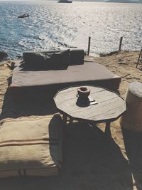 Table and chairs at beach by sea