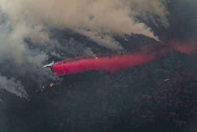 Airplane dropping fire retardant on wildfire in forest