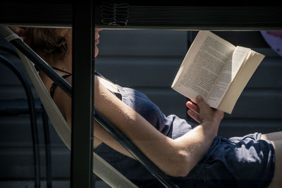 Low section of person sitting on book