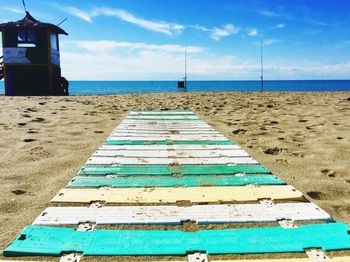 View of pier on beach against blue sky