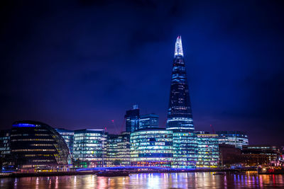 Illuminated city buildings against sky